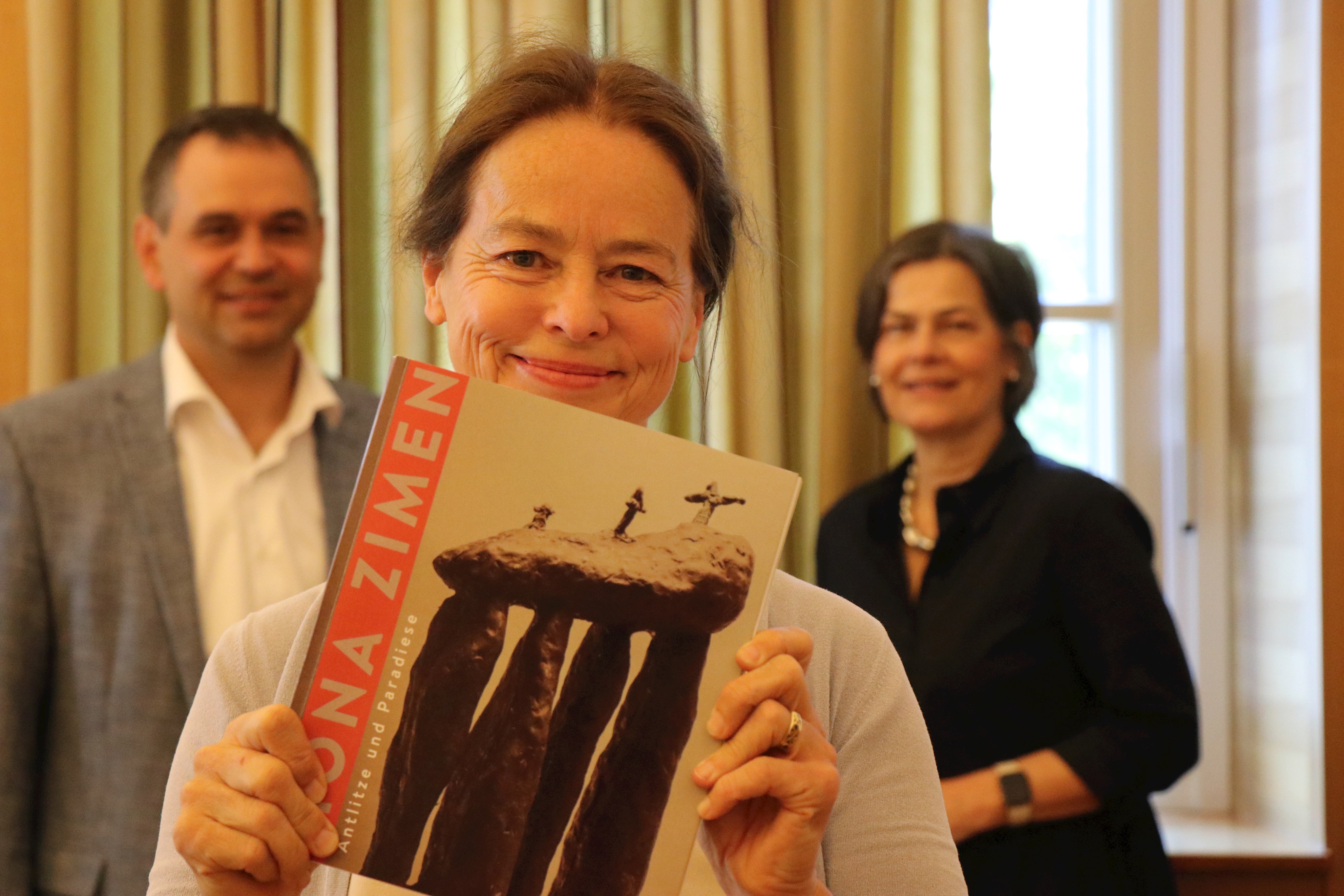 Präsentierte den Katalog zu ihrer Ausstellung: Mona Zimen (Mitte) mit Landrat Raimund Kneidinger und seiner Stellvertreterin im Amt, Verena Schwarz